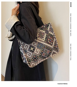 Detail of colorful ethnic woven canvas tote bag with geometric patterns and black strap