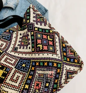 Dettaglio della trama etnica intrecciata colorata e tracolla nera della borsa tote in tela