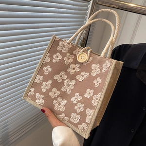 Linen tote bag with 3D floral texture, rope handles, and decorative wooden button
