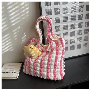 Detail of pink and white striped popcorn fabric tote bag with a cute plush pendant