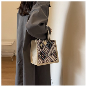 Nahaufnahme des ethnischen geometrischen Musters auf einer Canvas-Tasche mit Holzknopf