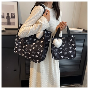 Detail of large canvas tote bag and mini pouch with heart print and plush heart charm