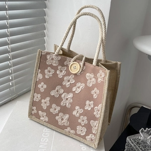 Linen bento tote bag with white floral embroidery and cotton rope handles in a 45-degree view