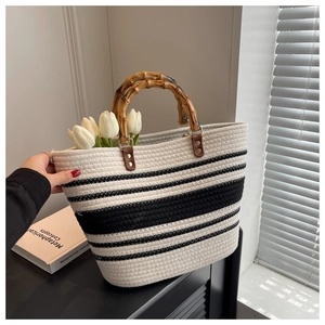 Detailed close-up of woven striped tote bag with retro bamboo handles and tulips