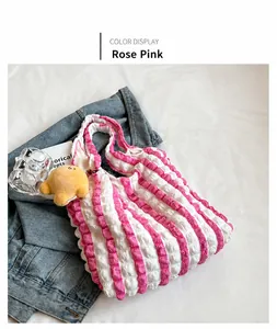 Detail of pink striped bubble fabric tote bag with star plush charm on denim