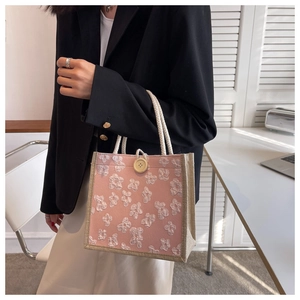 Pink woven tote bag with 3D floral accents and braided rope handles for women