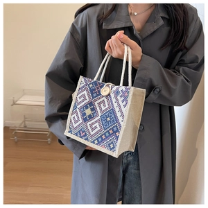 Ethno-Canvas-Tasche mit geometrischen Wellenmustern und Holzknopf-Verschluss im Detail