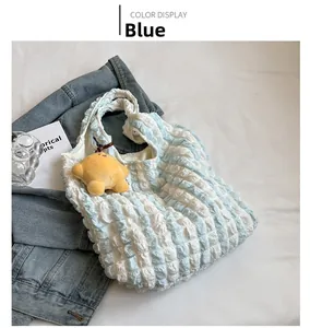 Detail view of blue cloud puff tote with bubble texture and yellow star plush charm