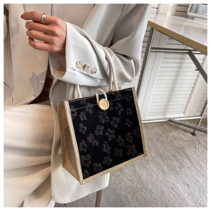 Linen canvas handbag with black floral design, wooden button and rope handle detail