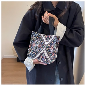 Detail of colorful geometric woven pattern on ethnic canvas tote bag with snap button