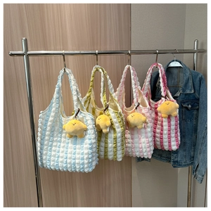 Detailed view of bubble texture tote bags in four colors with yellow star plush charms