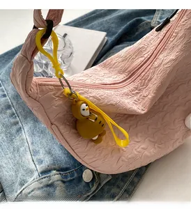 Detailed shot of pink pleated canvas bag with a cute yellow penguin charm accessory