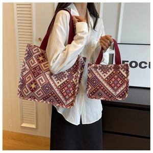 Macro shot of large and small ethnic geometric jacquard canvas tote bags with red handles