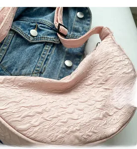 Close-up of pink crescent canvas bag with pleated texture and Good Luck cloud patch