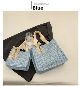 Detail view of large and small blue plaid tweed tote bags with lace bow ornaments