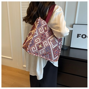 Close-up of ethnic geometric pattern canvas tote bag with wide crimson strap details