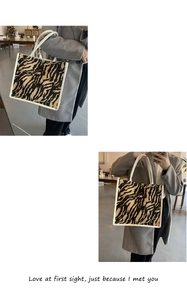 Dettaglio della borsa tote in tela zebrata indossata da una modella in interni moderni