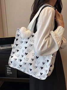 Large white canvas tote bag with black heart prints and wide shoulder strap