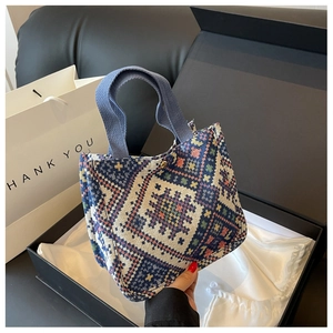 Detail of woven tote bag with ethnic geometric pattern and blue sturdy handles
