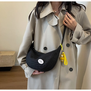 Detail of black crescent canvas crossbody bag with wrinkled texture and duck charm