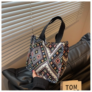 Close-up of ethnic tote bag with geometric patterns, thick handles and metal snap closure