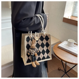 Detailed shot of checkered linen tote bag with cotton rope handles and cute rabbit charm