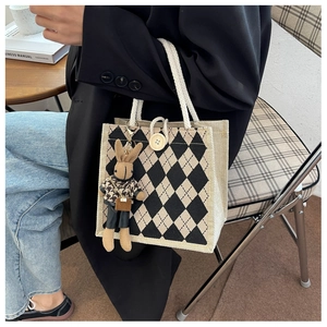 Close-up of diamond lattice linen tote with cotton rope handles and cute rabbit charm