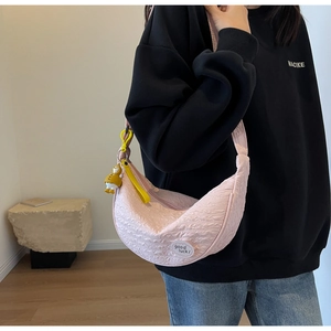 Pink crescent shoulder bag featuring pleated texture and cute cartoon duck charm detail