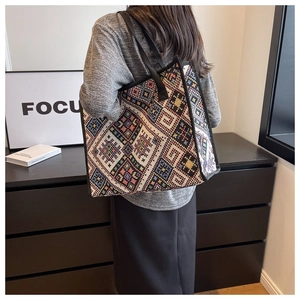 Sac cabas tissé style ethnique aux motifs géométriques colorés porté par un modèle