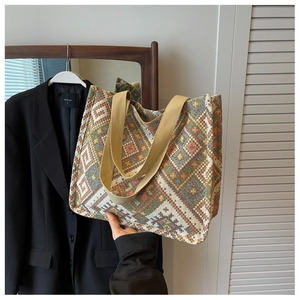 Close-up of geometric jacquard fabric and beige canvas handles on a large tote bag