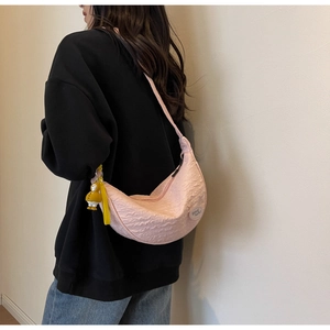 Detail of pink pleated crescent bag with yellow duck pendant and good luck patch