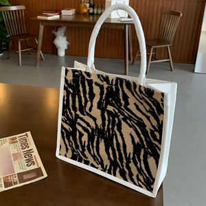 Borsa tote in tela moderna con stampa animalier e finiture bianche su tavolo legno