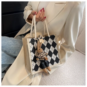 Close-up of linen tote with black and white checker pattern and plush rabbit charm