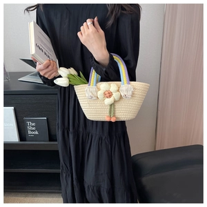 Detail of straw woven handbag with colorful handle and 3D flower charm