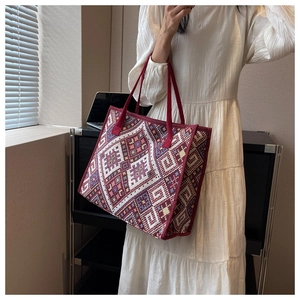 Détail d'un sac cabas ethnique en toile avec motifs géométriques bordeaux et anses
