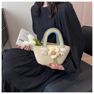 Detail of handmade straw basket bag featuring rainbow handle and large flower charm