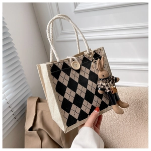 Close-up of linen tote bag with black and beige rhombus pattern and cute bunny charm