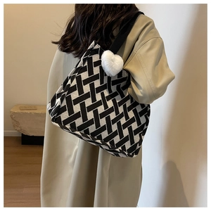 Detail of large woven tote bag with black and white geometric pattern and heart charm