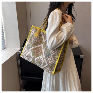 Sac cabas ethnique en toile à motifs géométriques porté par un mannequin en robe