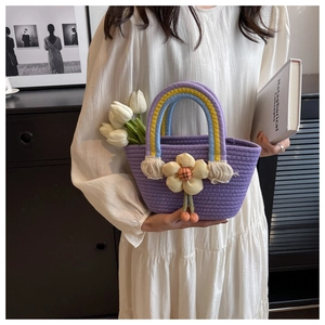 Detailed close-up of handmade purple woven basket with rainbow handle and sunflower charm