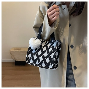 Detail of checkered canvas tote bag with heart charm and secure snap closure