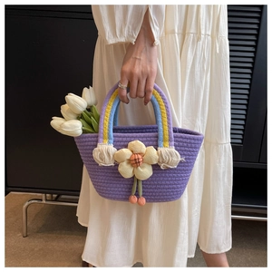 Detail of purple woven cotton tote bag with rainbow handle and yellow flower charm