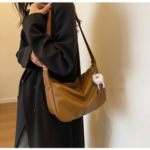 Brown hobo shoulder bag with wide strap and funny plush charm on textured leather