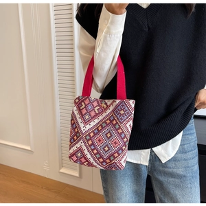 Close-up of ethnic canvas bucket bag with colorful geometric patterns and gold metal buckle