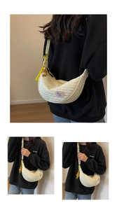 Detail of cream crescent canvas bag featuring quilted texture and yellow duck charm accessory