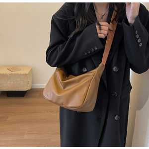 Detail of caramel lychee grain crescent bag featuring a stylish wide fabric shoulder strap