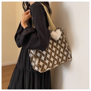 Detail view of large geometric tote bag with heart charm and webbing handles