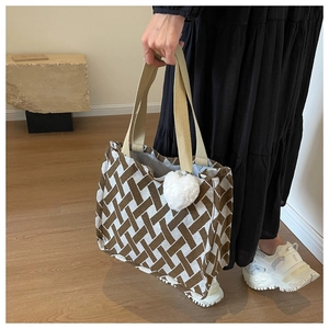 Detail of woven texture canvas tote with geometric pattern and plush heart charm