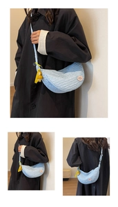Detail of blue crescent canvas bag with textured fabric and yellow duck charm