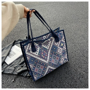 Détail d'un sac cabas en toile tissée géométrique avec sangles bleues renforcées